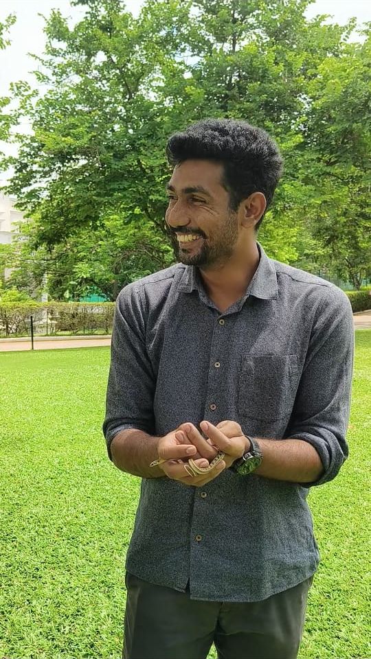 Manoj smiling while holding a small snake